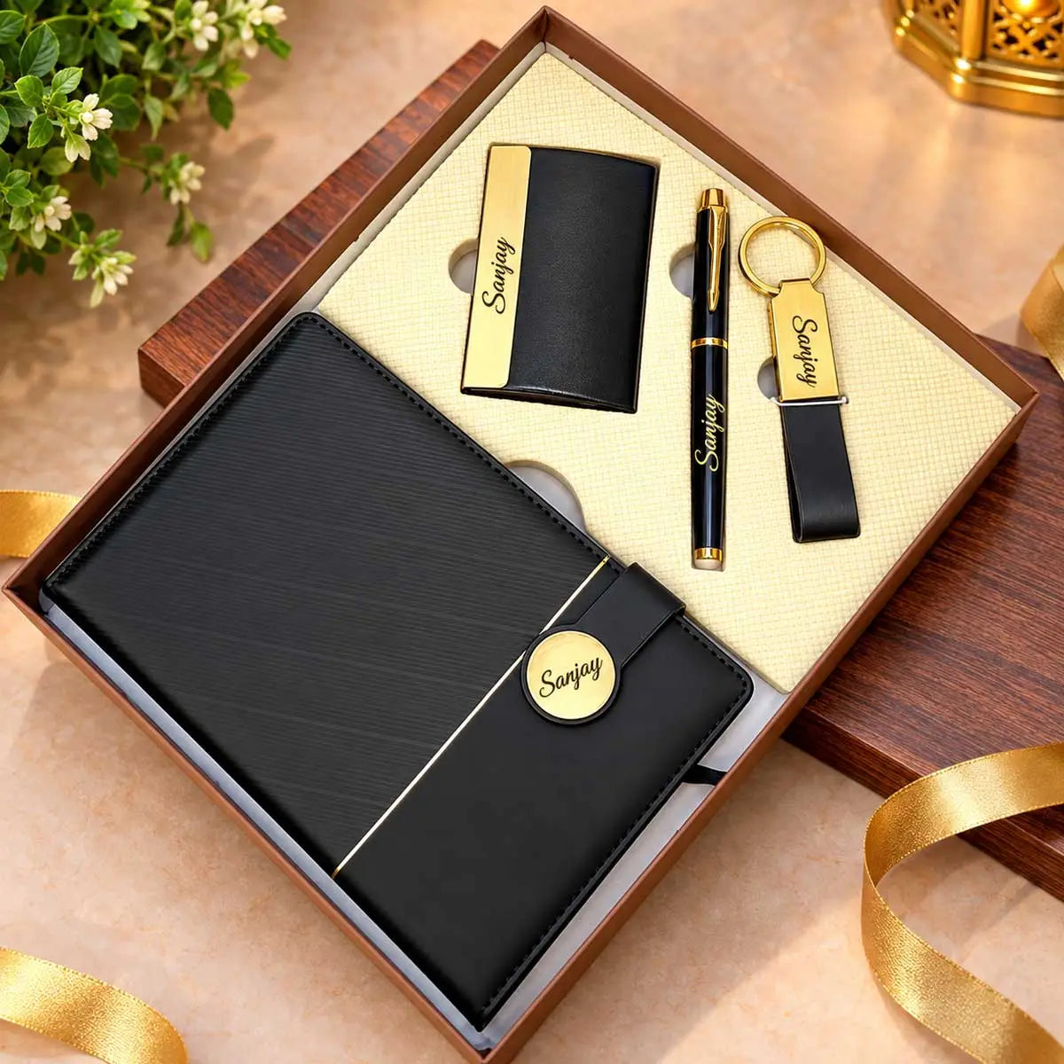 Personalized black and gold 4-in-1 gift set with A5 diary, metal pen, keychain and card holder in a gift box.